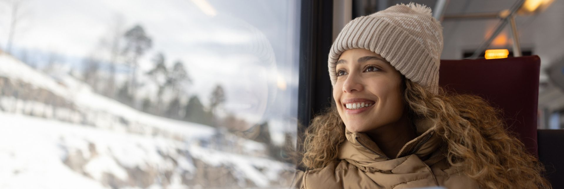 Femme souriante regardant à l'extérieur par la fenêtre du train