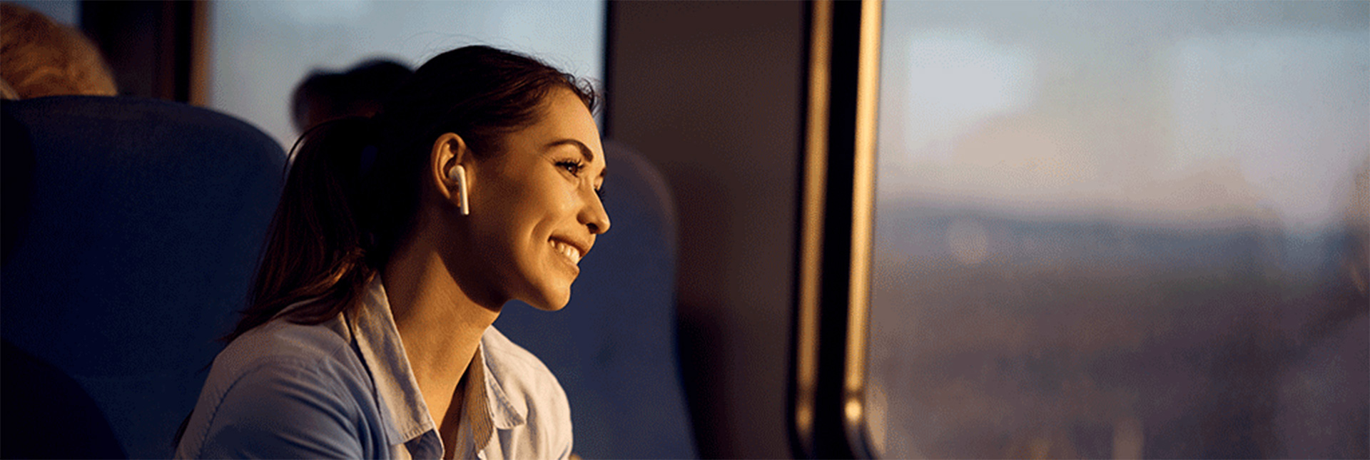 Femme souriante regardant par la fenêtre d'un train