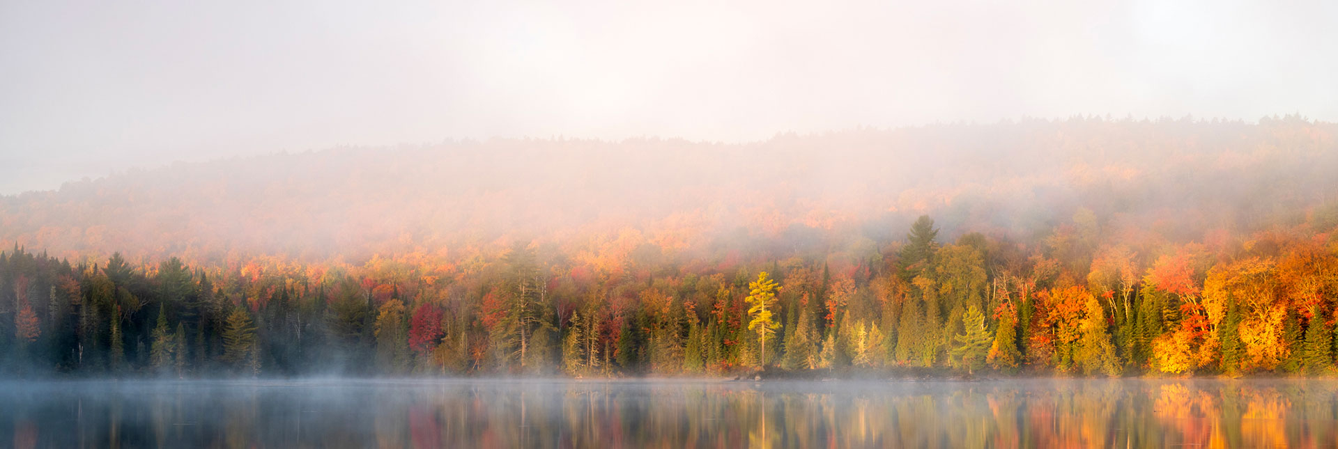 Berge d'un lac près d'un mont avec du brouillard à l'automne