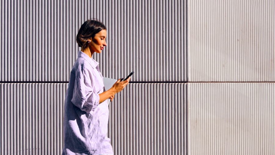Woman walking while reading on her phone