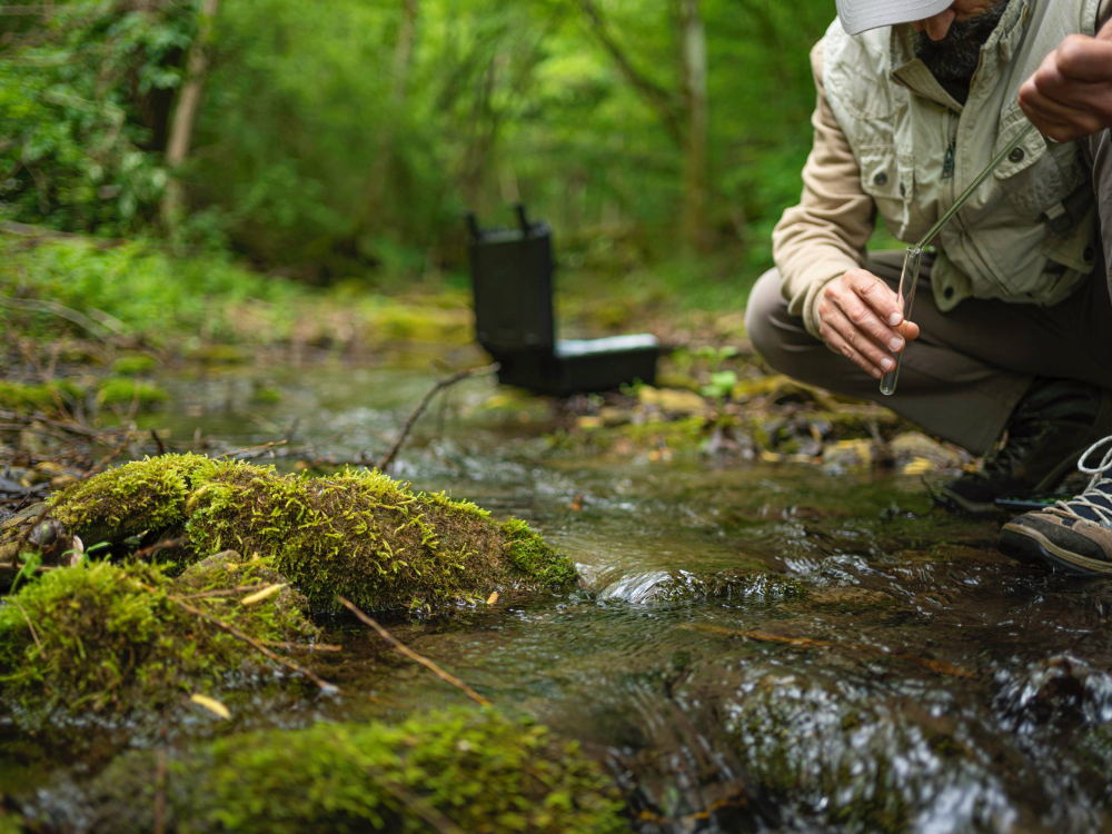 Scientist collecting a water sample in a test tube